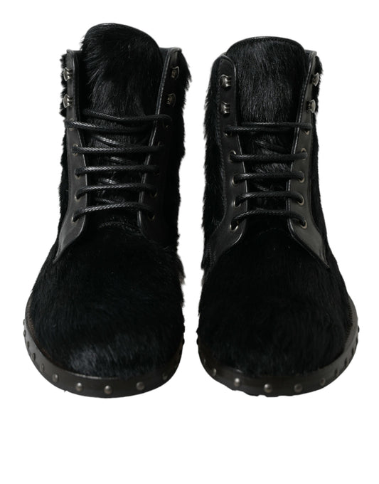 Pair of black fur boots with metal studs and laces