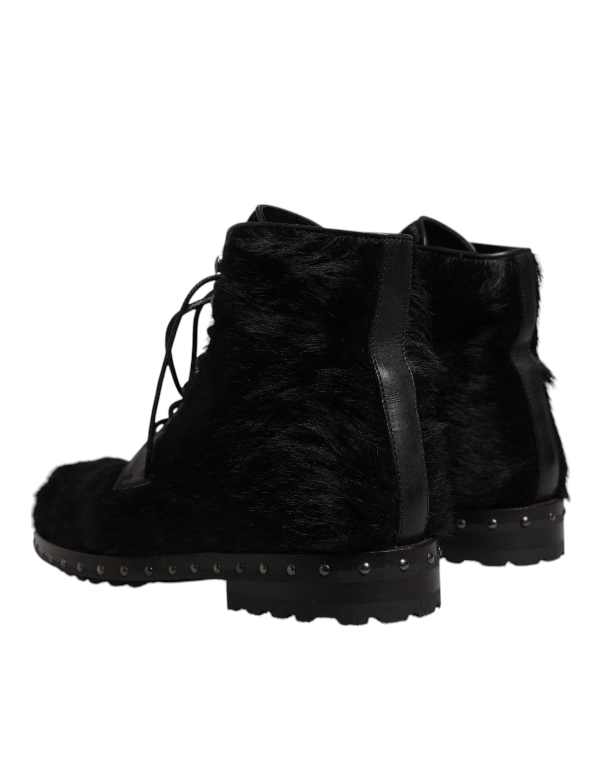 Pair of black fur lined boots with laces and studs on soles