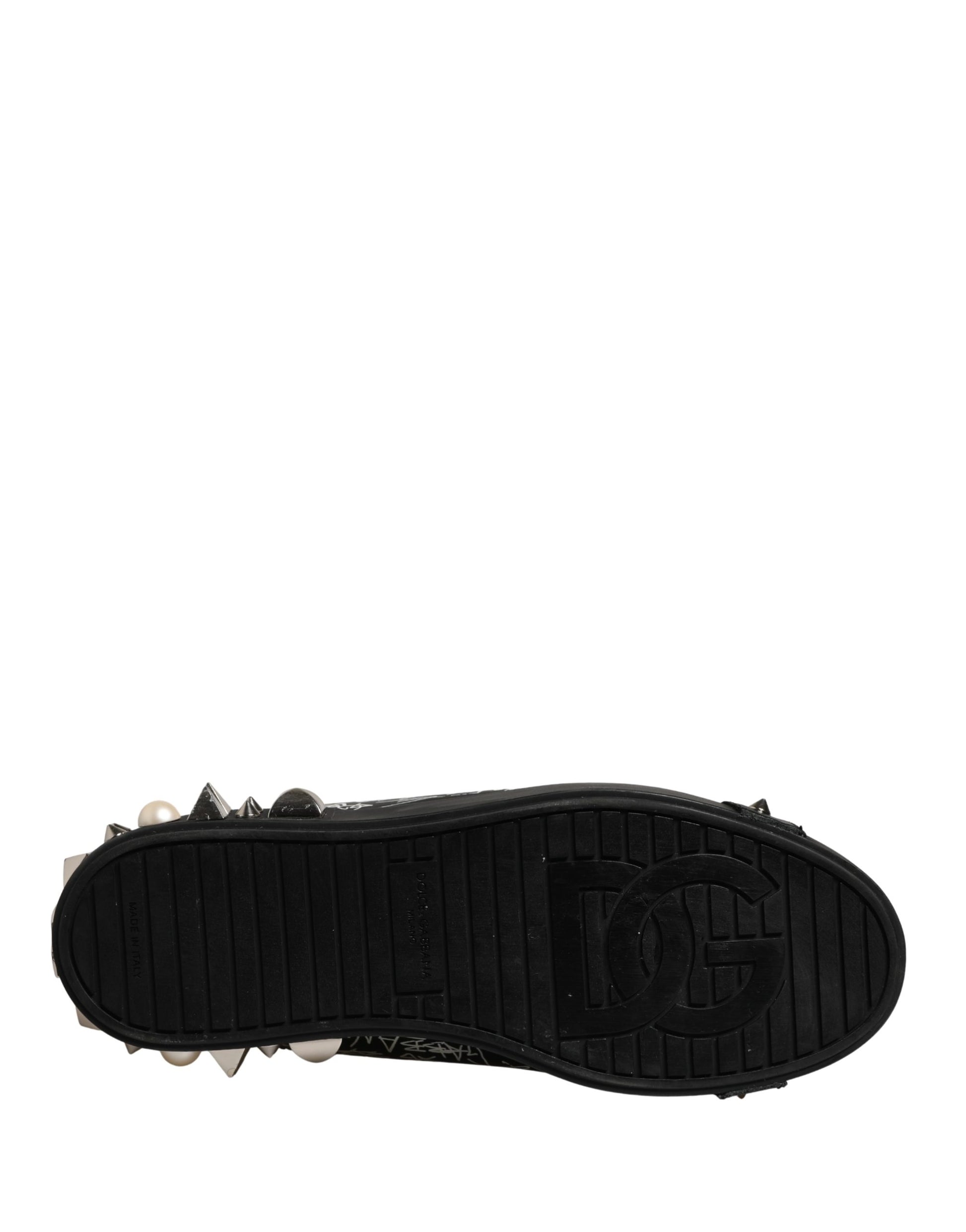 A single black sneaker with a graffiti design on the side and studs on the sole