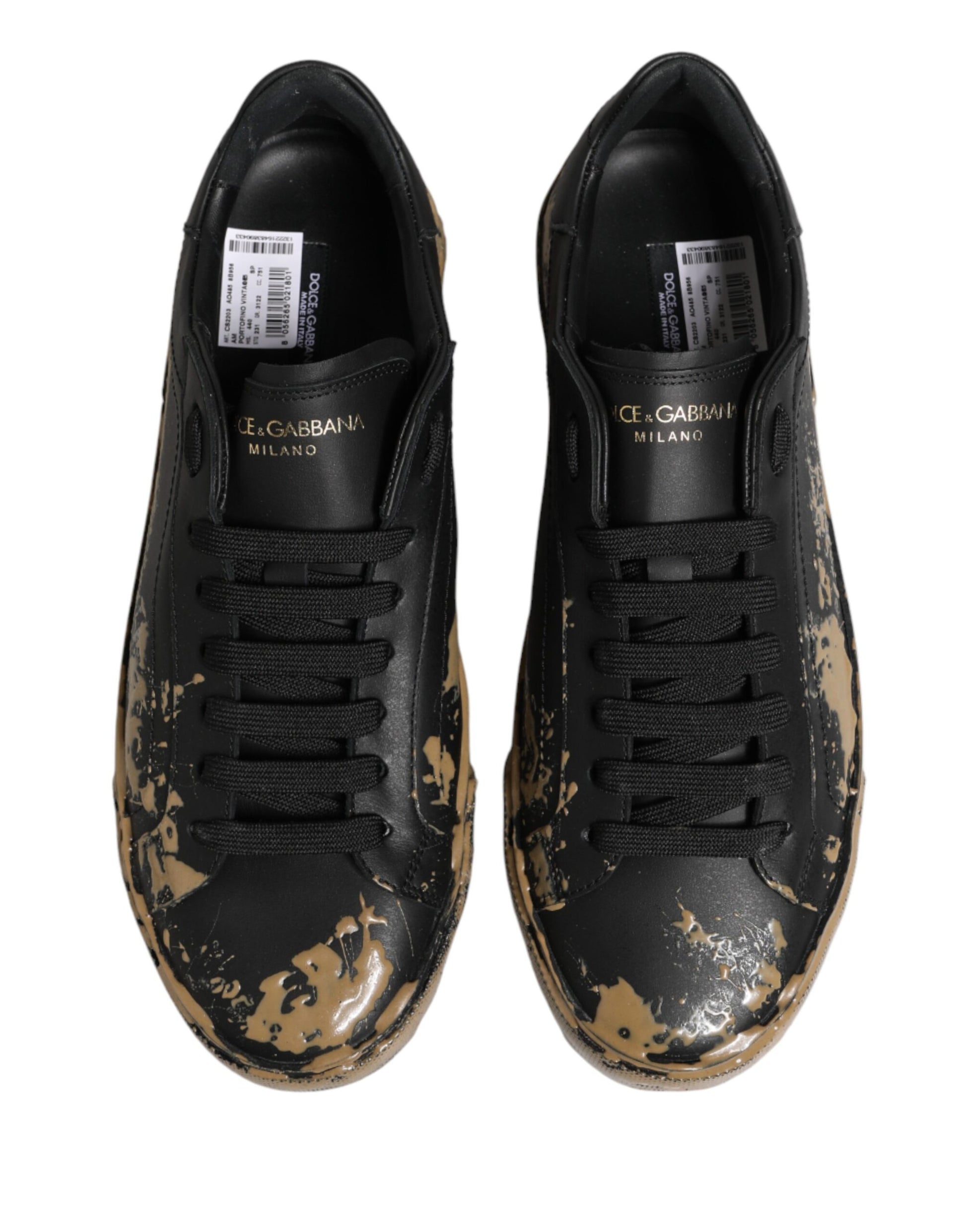 Pair of black sneakers with mud effect, featuring a low top and laces