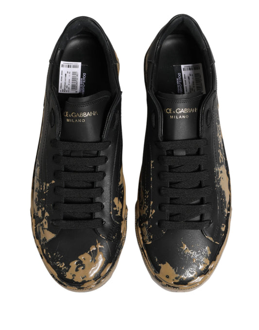 Pair of black sneakers with mud effect, featuring a low top and laces