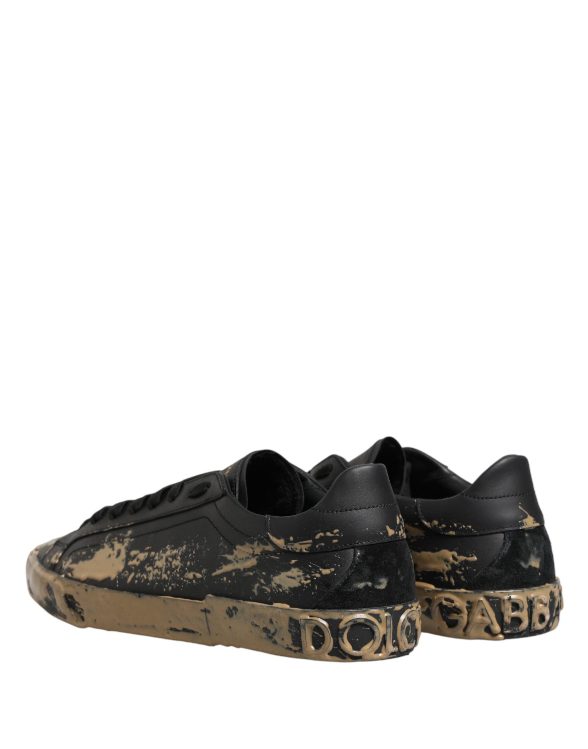 Pair of black sneakers with mud effect and gold accents, featuring the Dolce & Gabbana logo