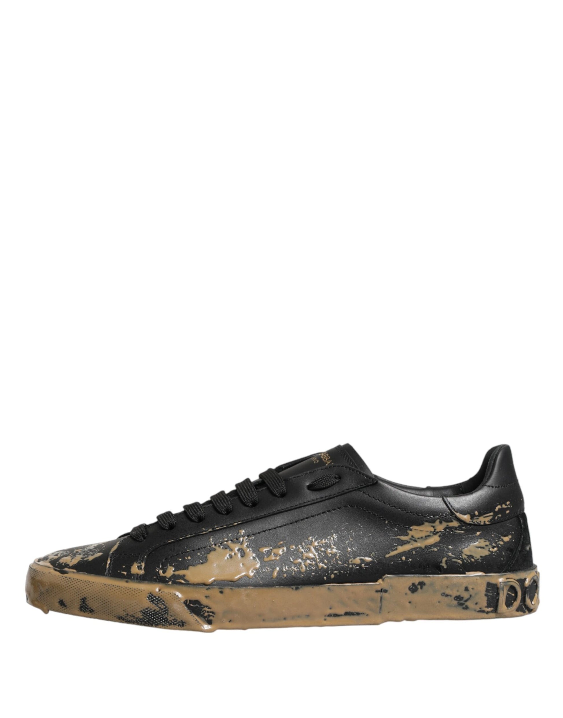 A pair of black sneakers with mud effect and gold accents, featuring a low top design