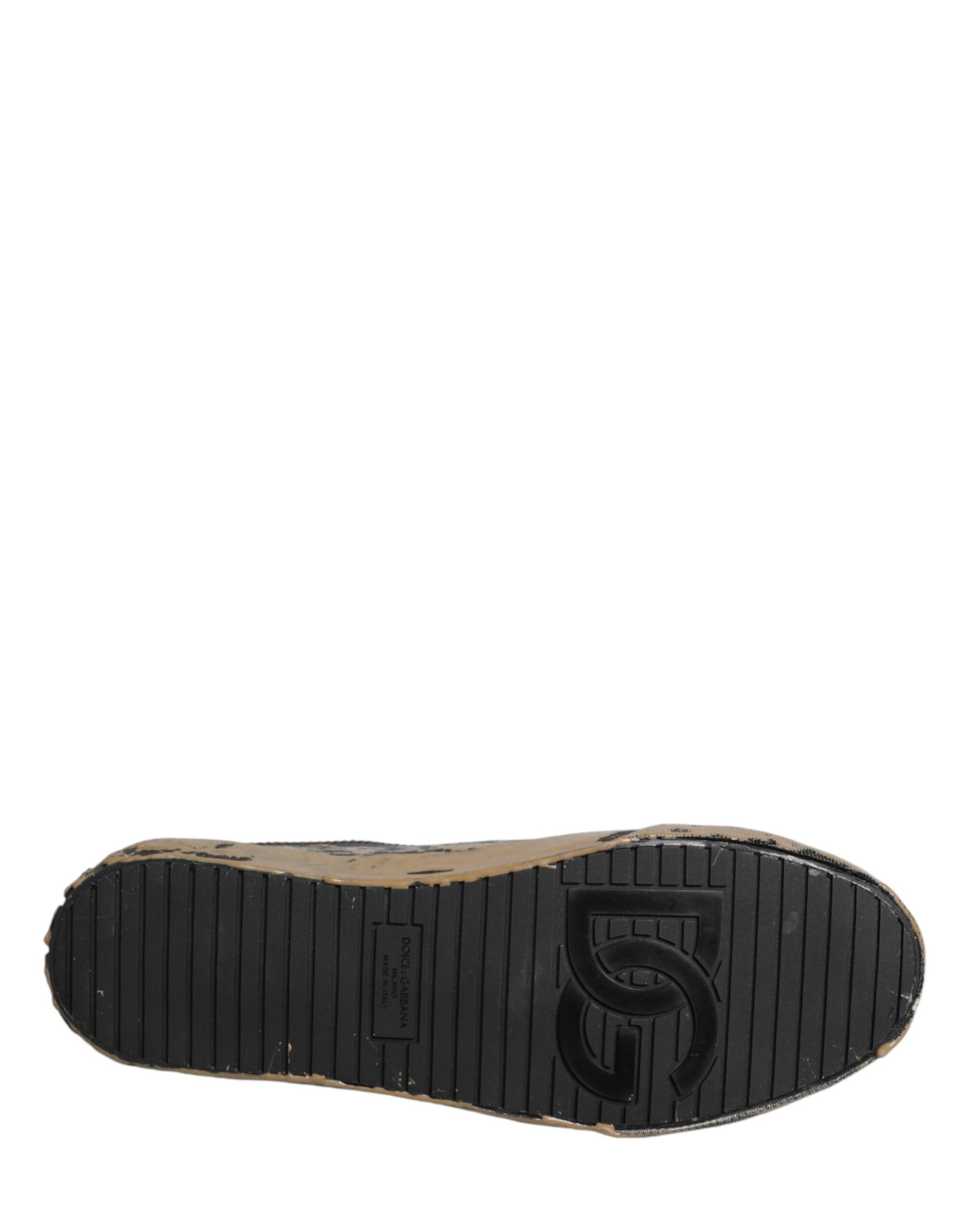 A single black shoe with a mud effect, featuring the Dolce & Gabbana logo on the side