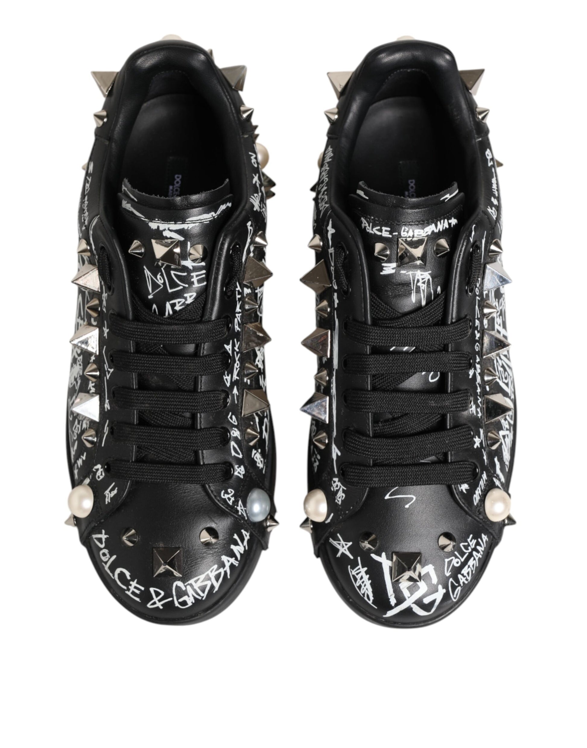 Pair of black studded sneakers with white text and stars on sides, featuring laces and metal embellishments