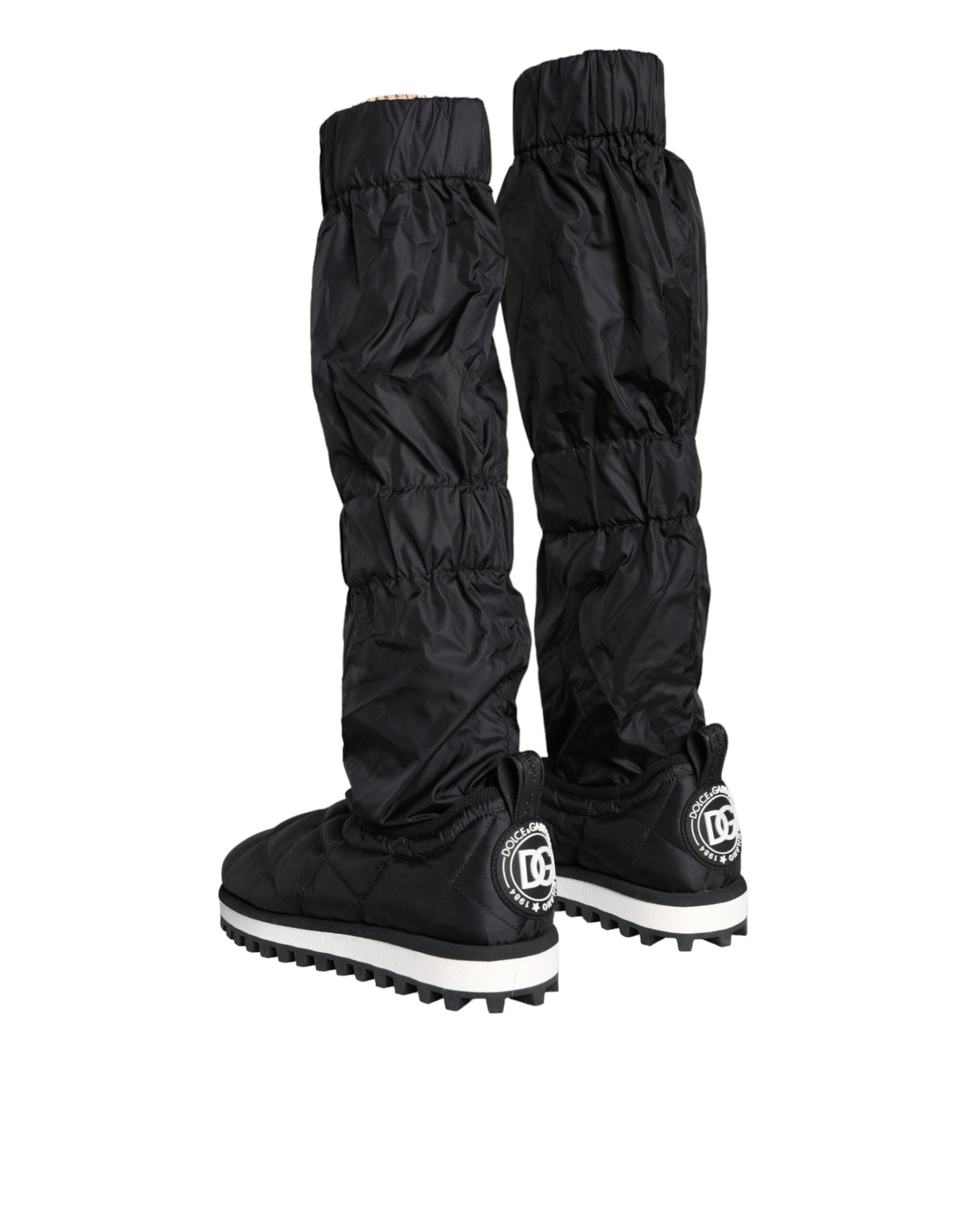 Pair of black rain boots with white soles and a logo on the side