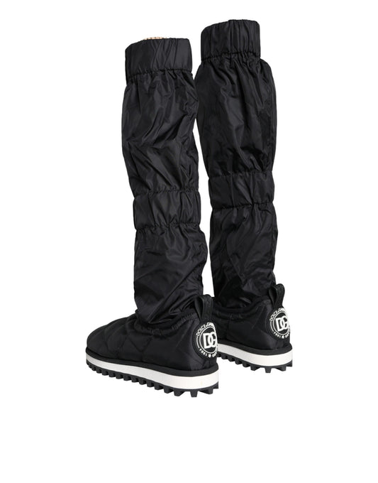 Pair of black rain boots with white soles and a logo on the side