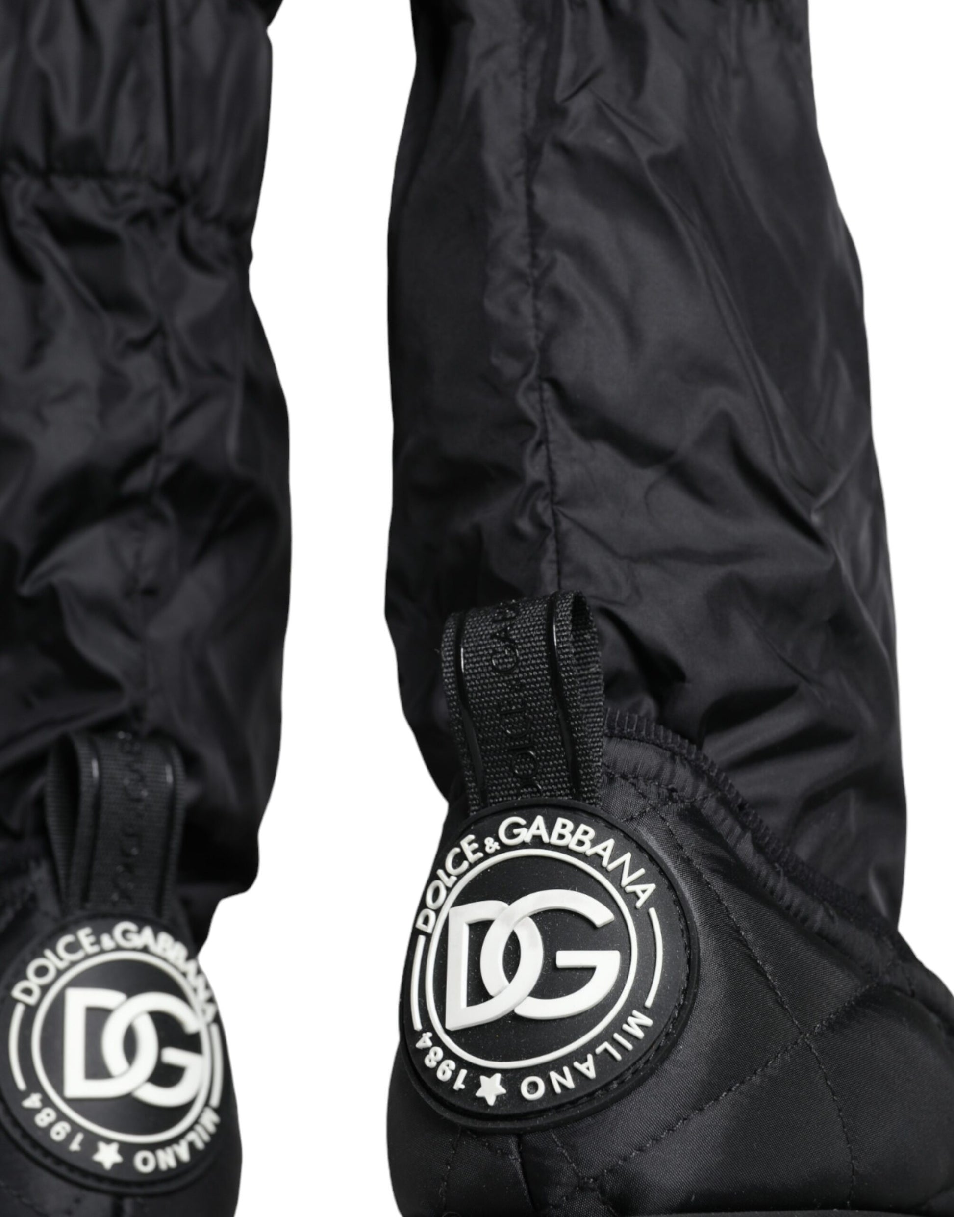 Pair of black rain pants with white logo on side and bottom