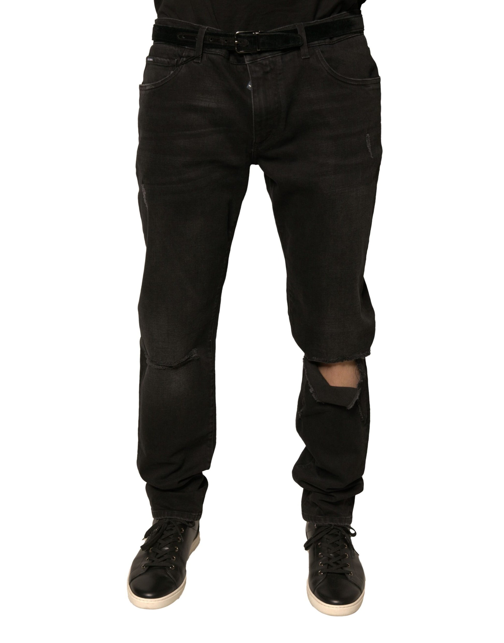 Pair of black denim jeans with distressed areas on legs