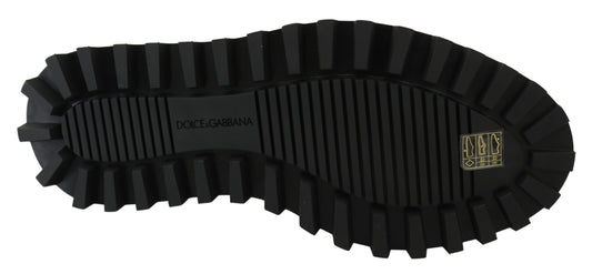 Black rubber boot with deep treads and a logo on the side