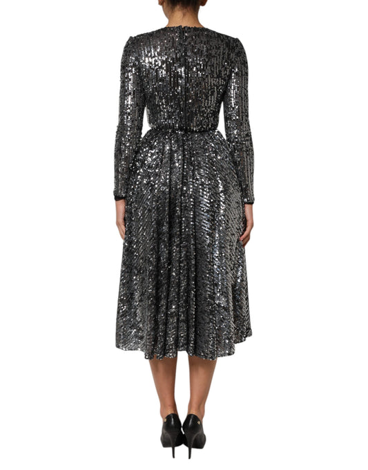 A black sequined midi dress with long sleeves and an A-line skirt