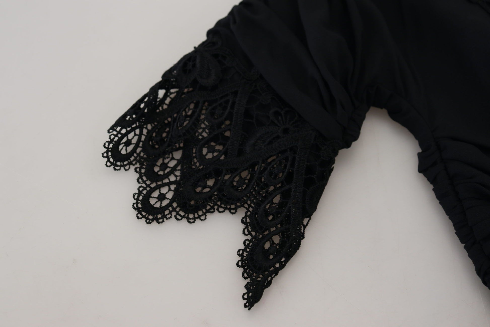 A black lace sheath dress with a midi length and body-con fit