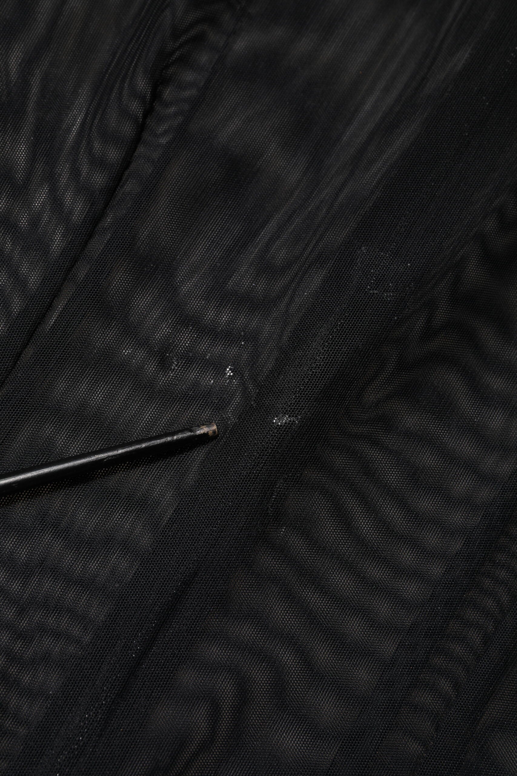 A black sheer mesh long sleeve jumpsuit with a zipper