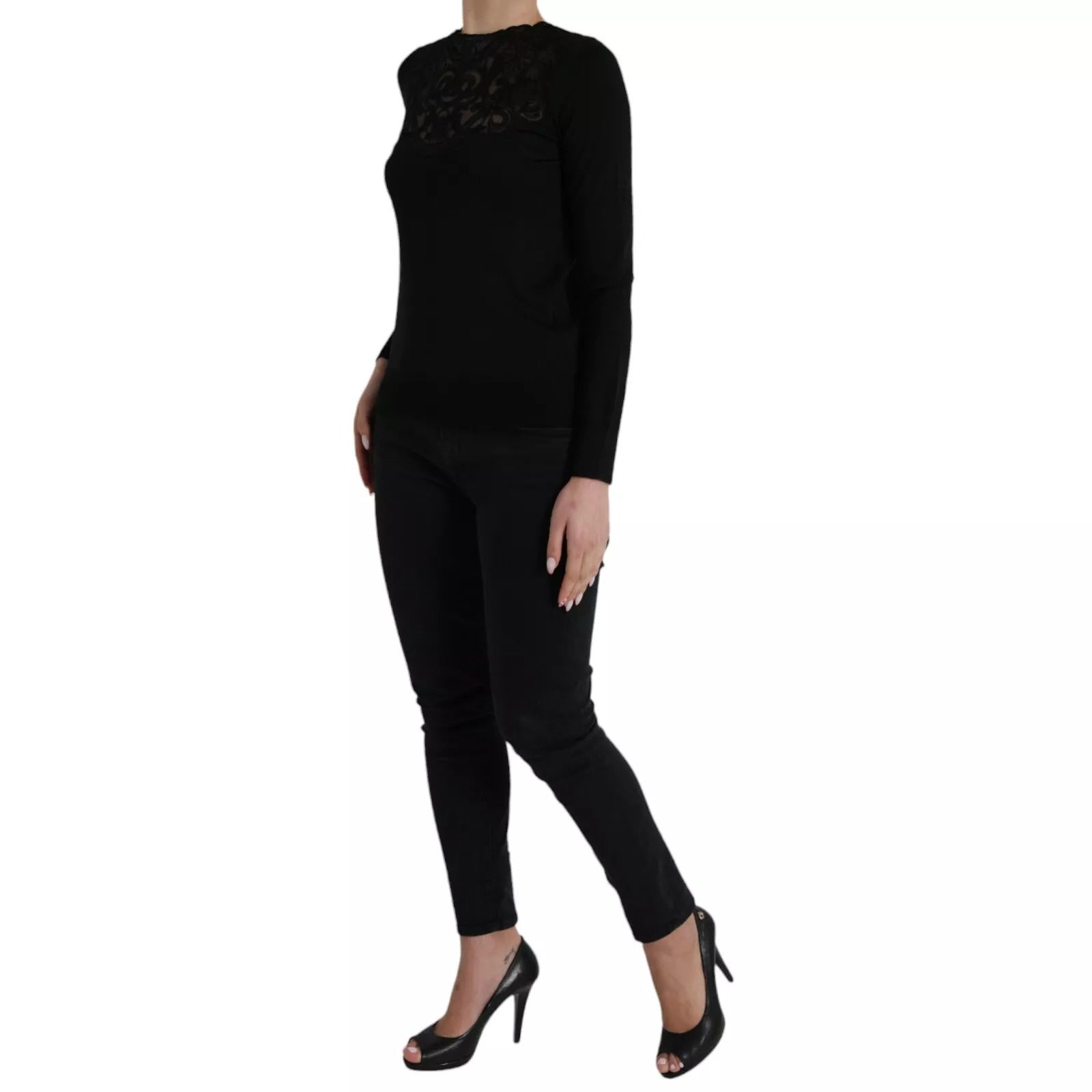 Woman wearing black top and pants, standing on one leg
