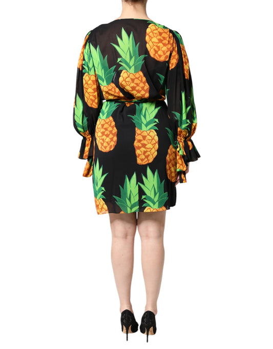 A black silk dress with a pineapple print, featuring draped sleeves and a wrap style
