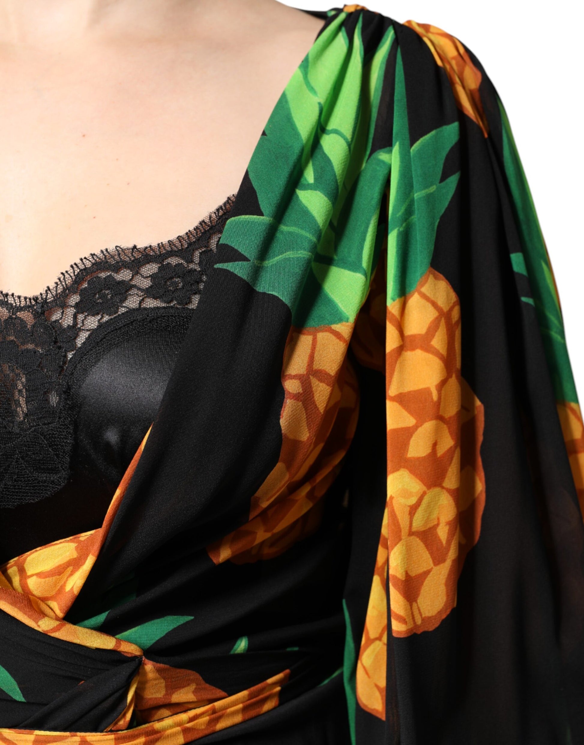 A black silk wrap dress with a pineapple print, featuring draped sleeves and a v-neckline
