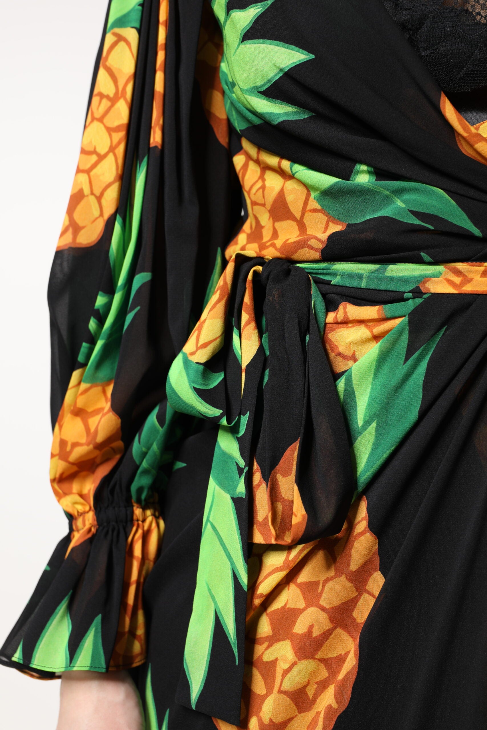 A black silk dress with a pineapple print and draped sleeves