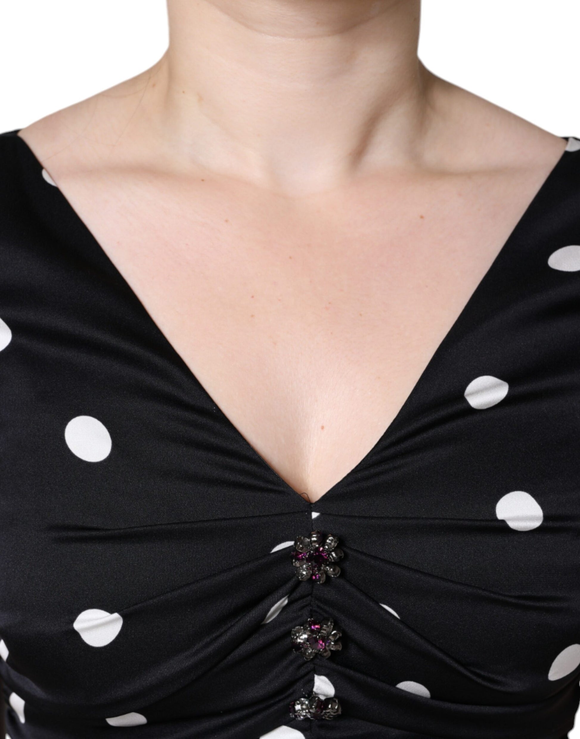 A black silk polka dot dress with a V-neck and tassels
