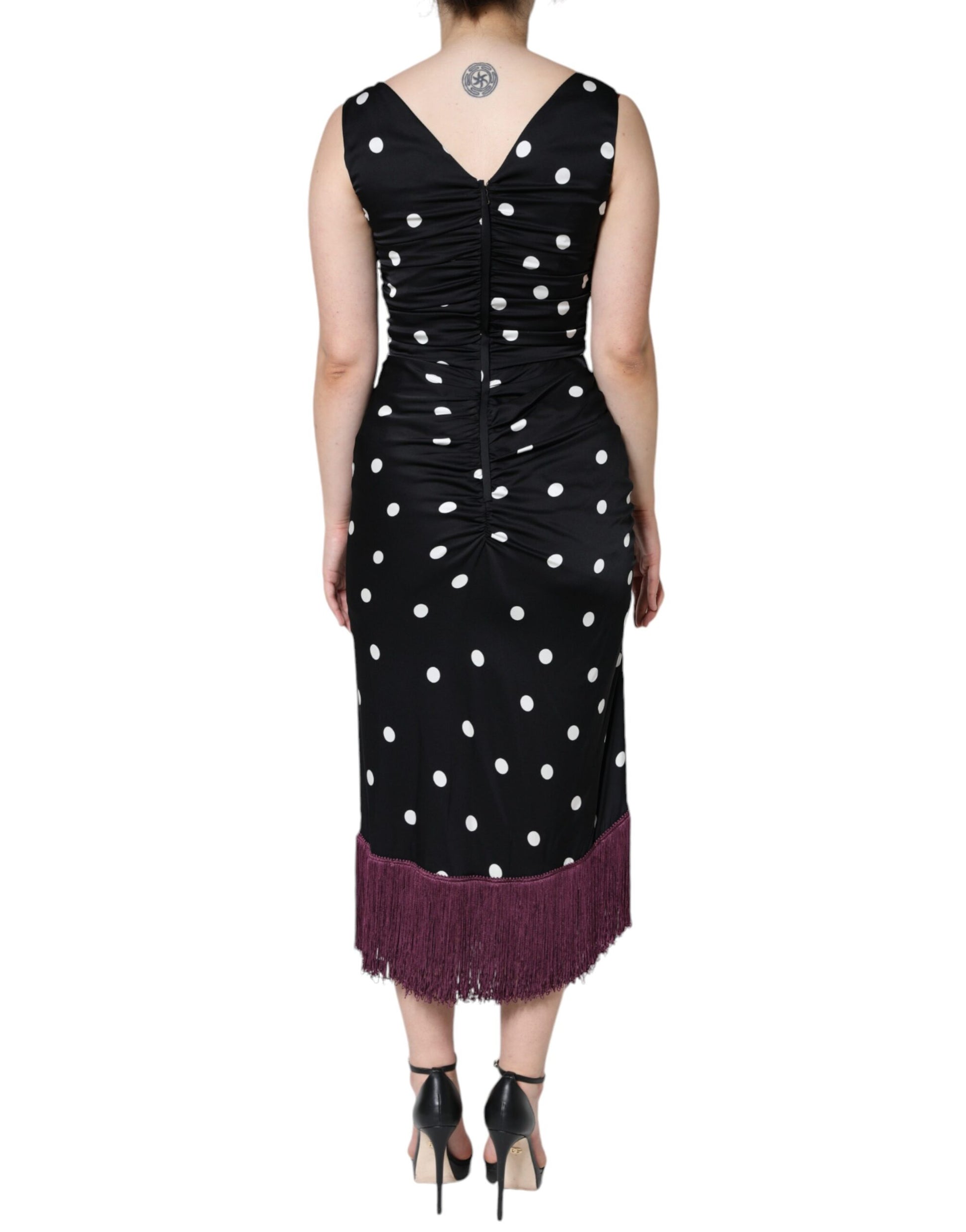 A black silk midi dress with polka dots and tassels