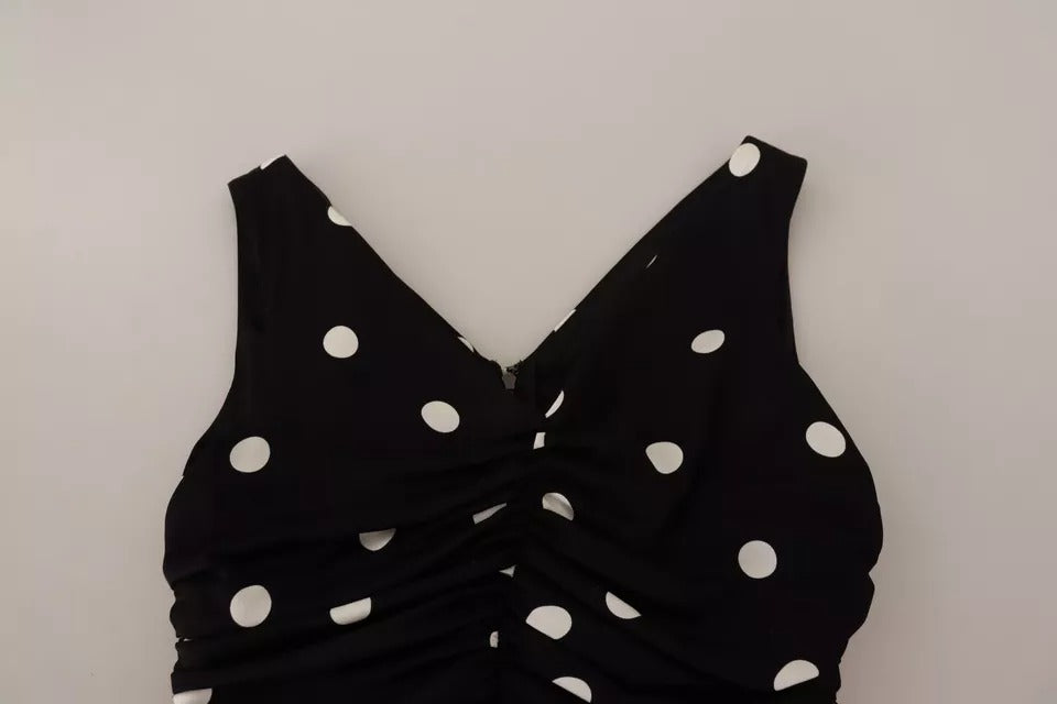 A black silk dress with white polka dots, featuring a V-neck and midi length