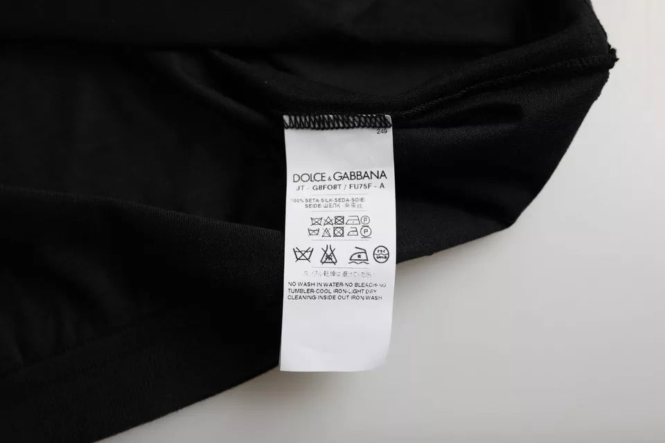 Black t-shirt on white surface with tag attached to neckline