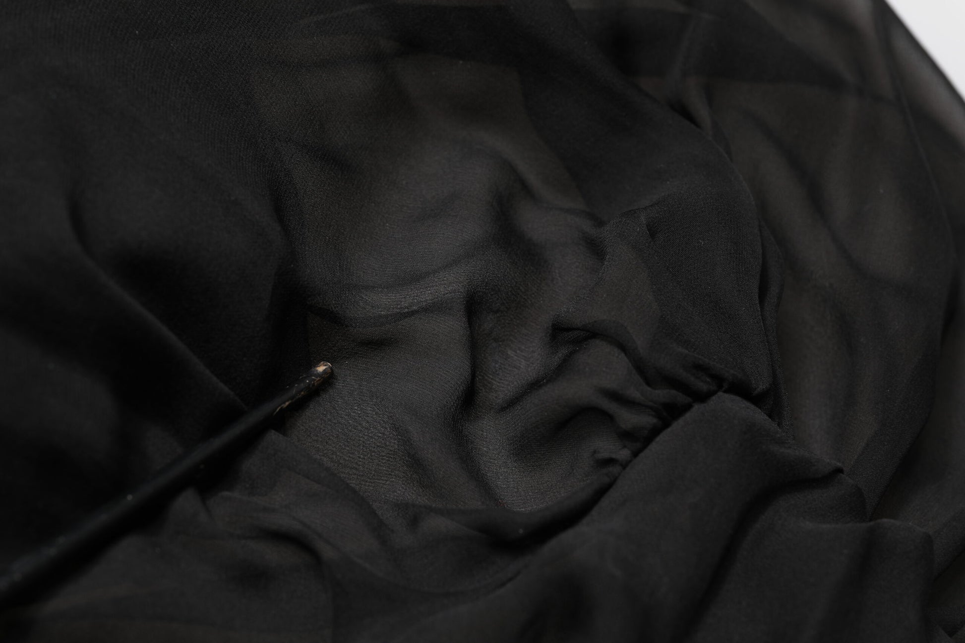 A black silk tulle dress with long sleeves and a V-neck