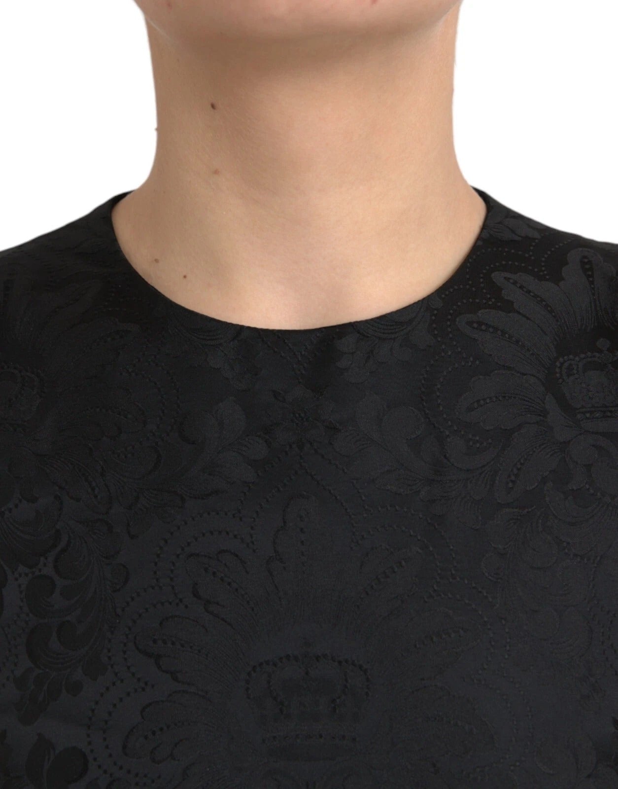 A black sleeveless bodycon dress with an A-line silhouette. It features a lace neckline and is designed by Do