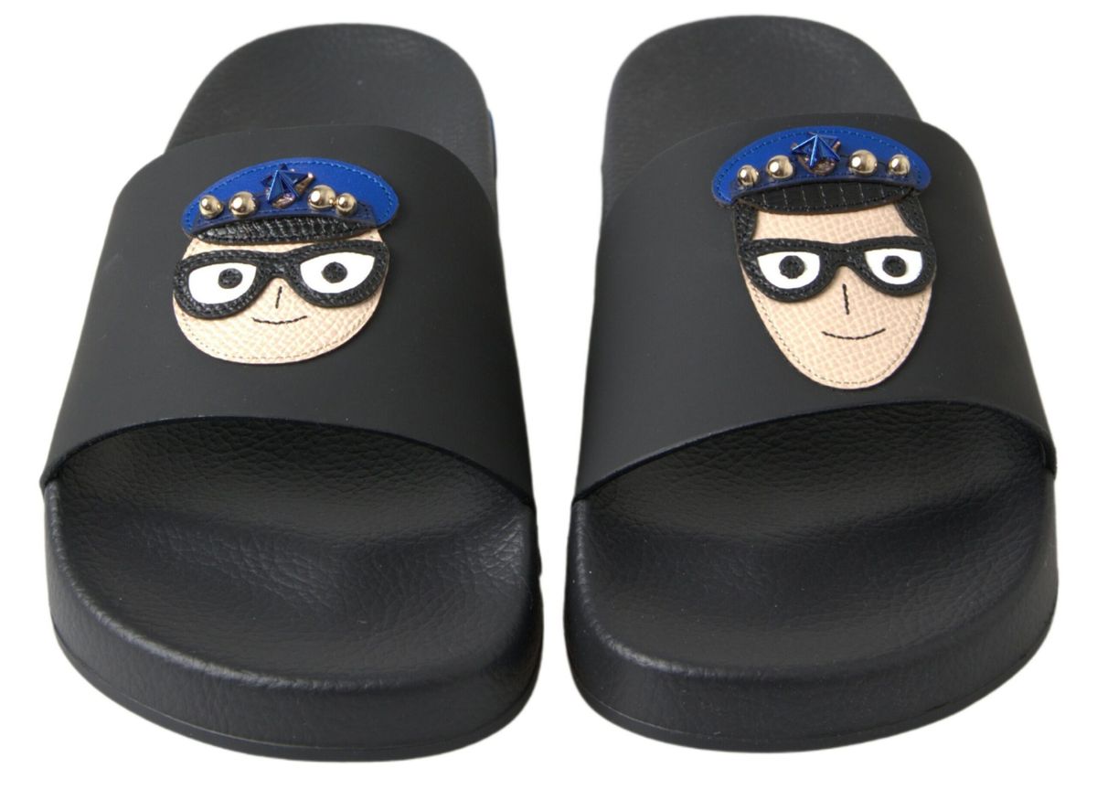Pair of black flip flops with cartoon character faces on soles