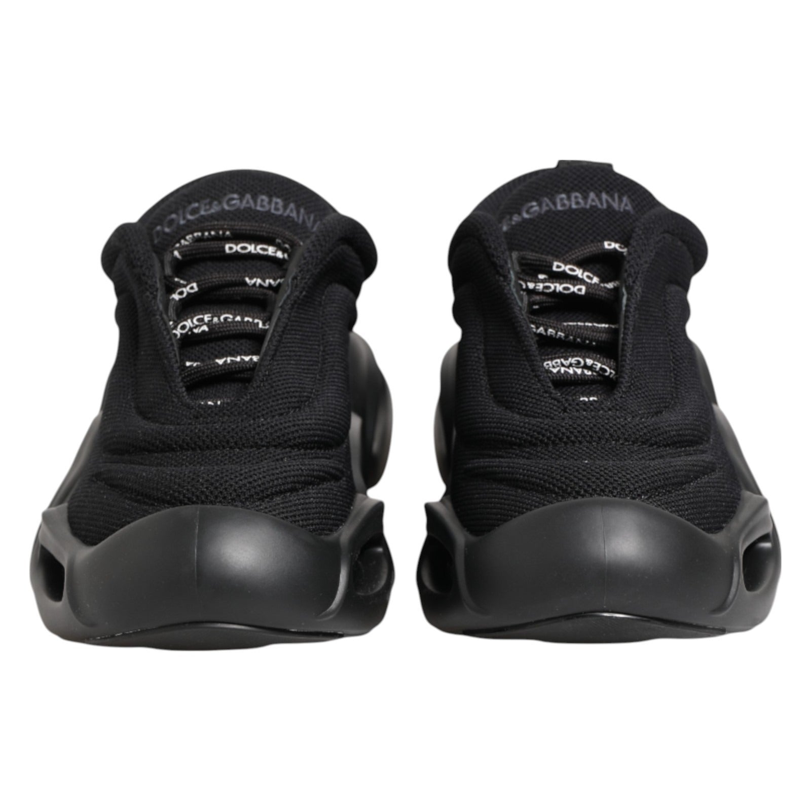 Pair of black slip-on shoes with white logo and text on side