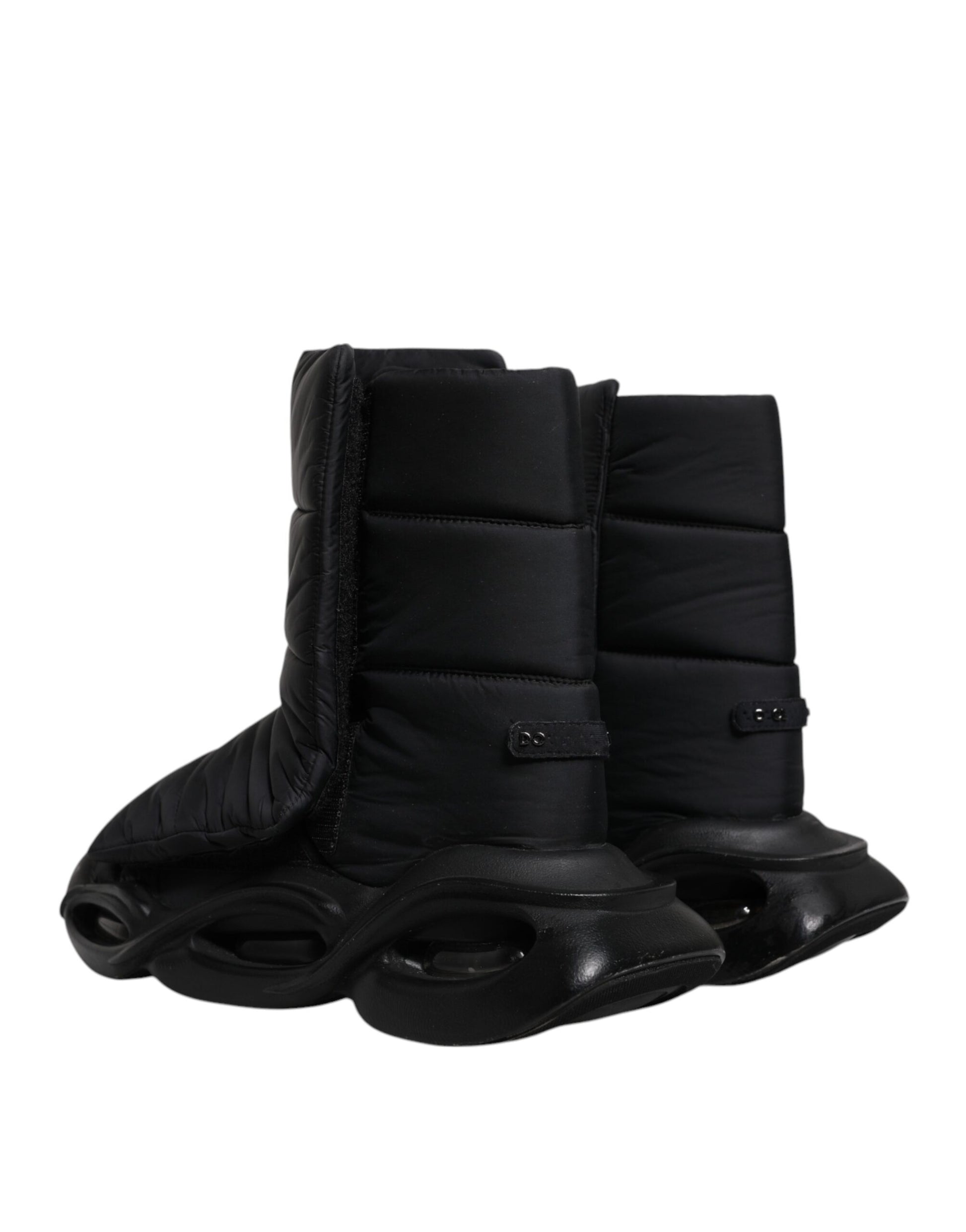 A pair of black slip-on shoes with quilted design and wave pattern