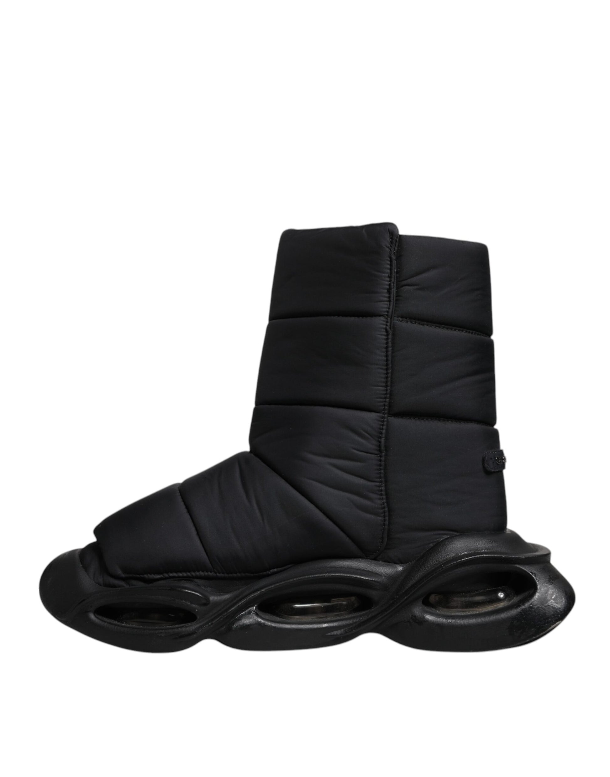 A pair of black quilted slip-on shoes with a wave pattern design