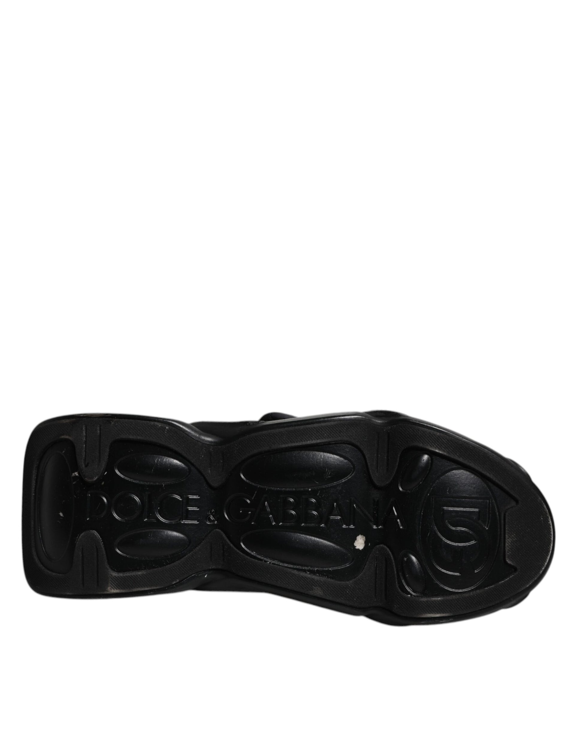 A black slip-on shoe with a quilted design and the word "Dolce & Gabbana" visible on it