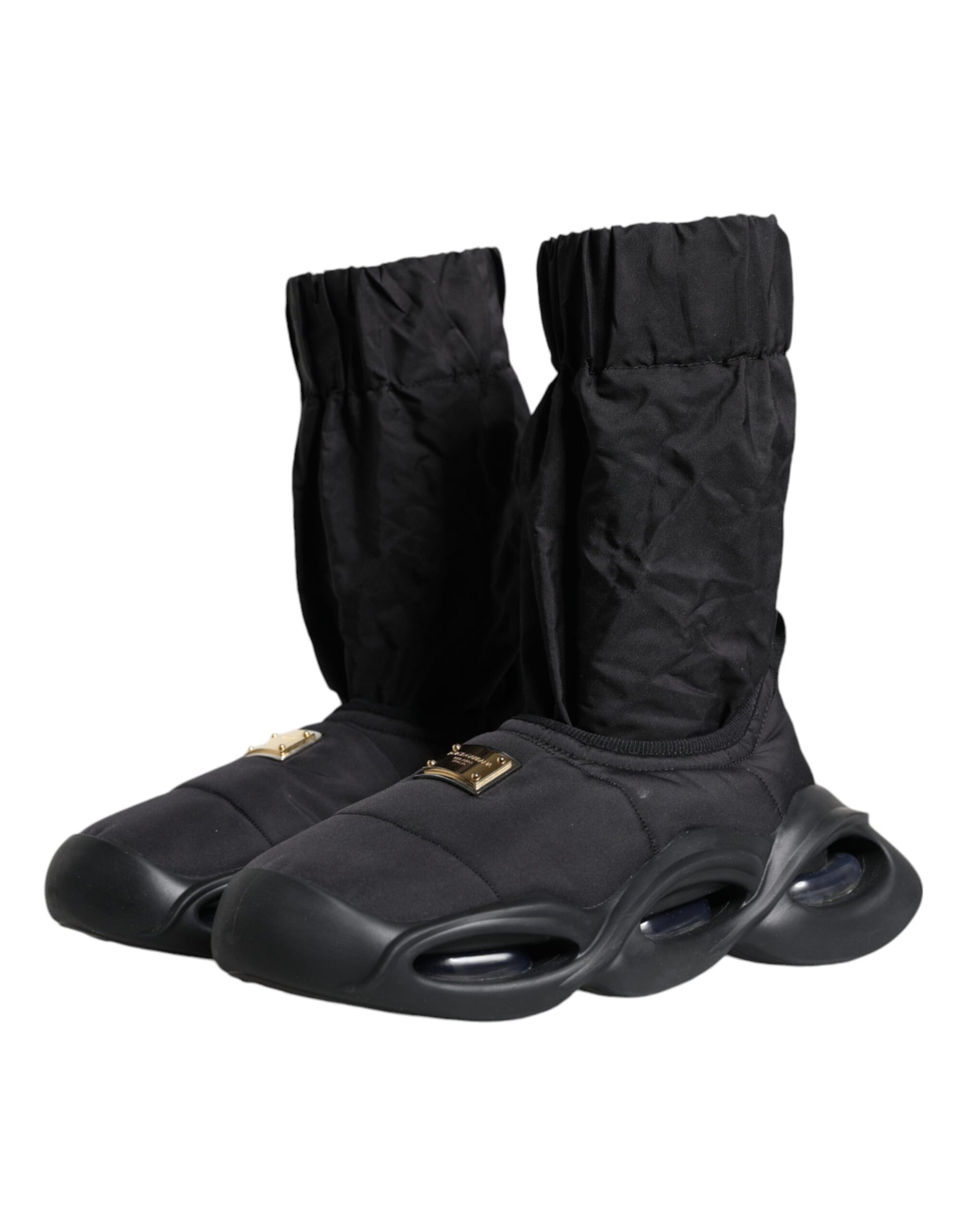 Pair of black boots with white soles and gold buckles