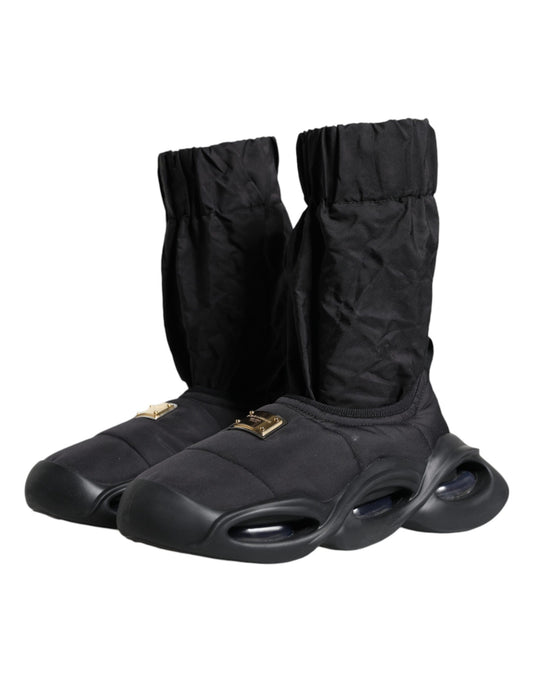 Pair of black boots with white soles and gold buckles