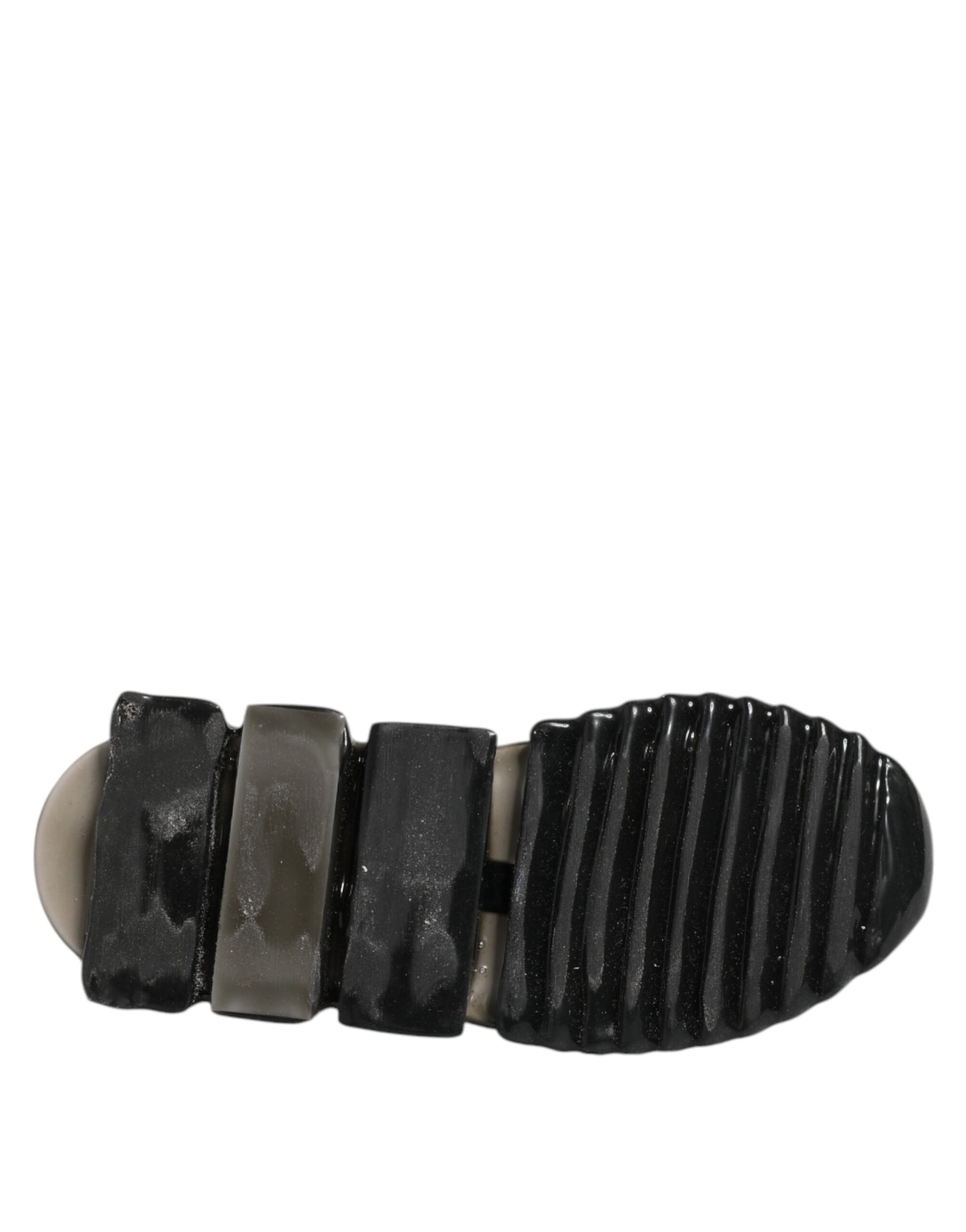 A black slip-on shoe with a textured sole and a small logo on the side