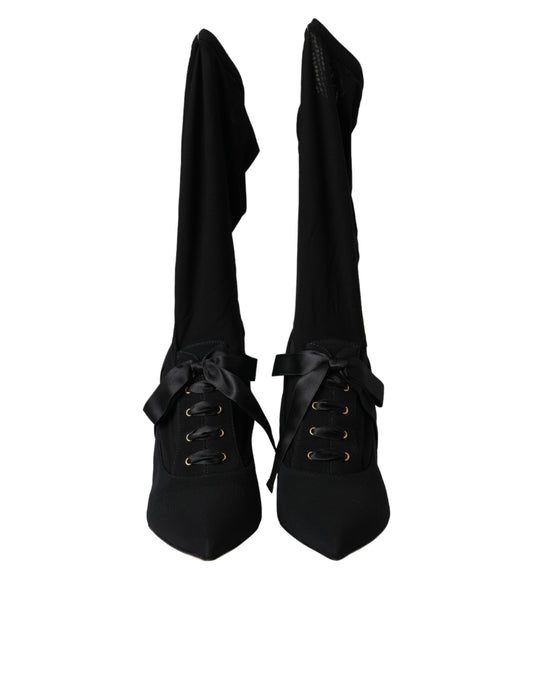 Pair of black knee high boots with laces and buckles