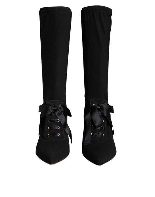 Pair of black knee high boots with laces and buckles
