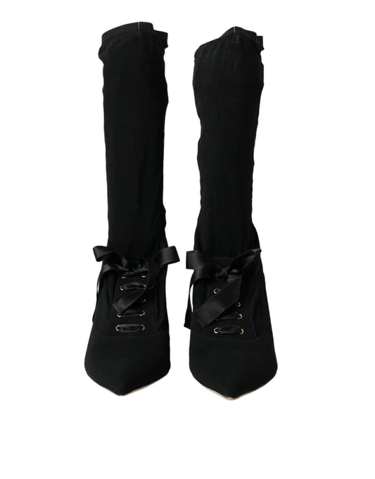 Pair of black knee high boots with laces and buckles