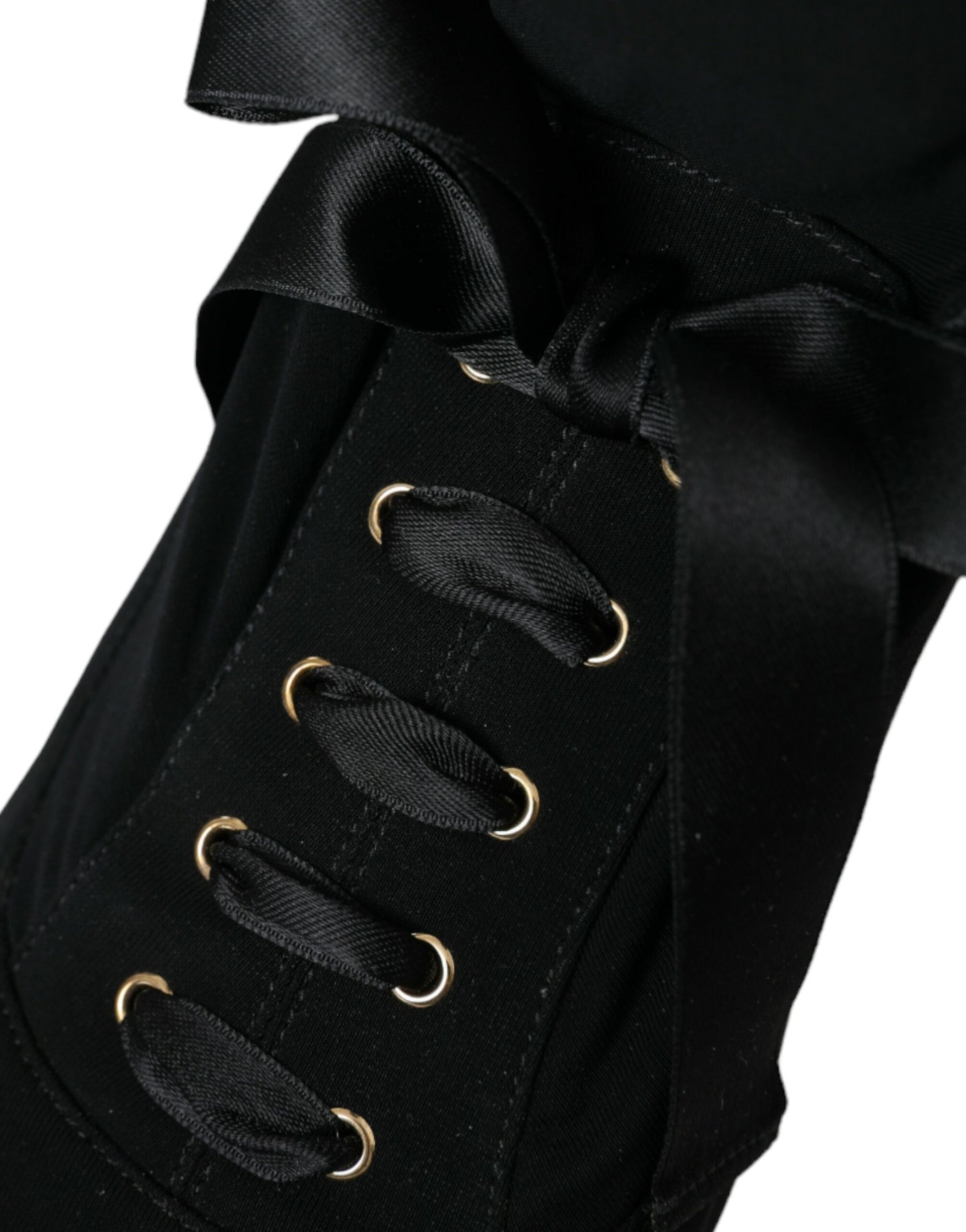 Black shoe with gold buttons and a black bow
