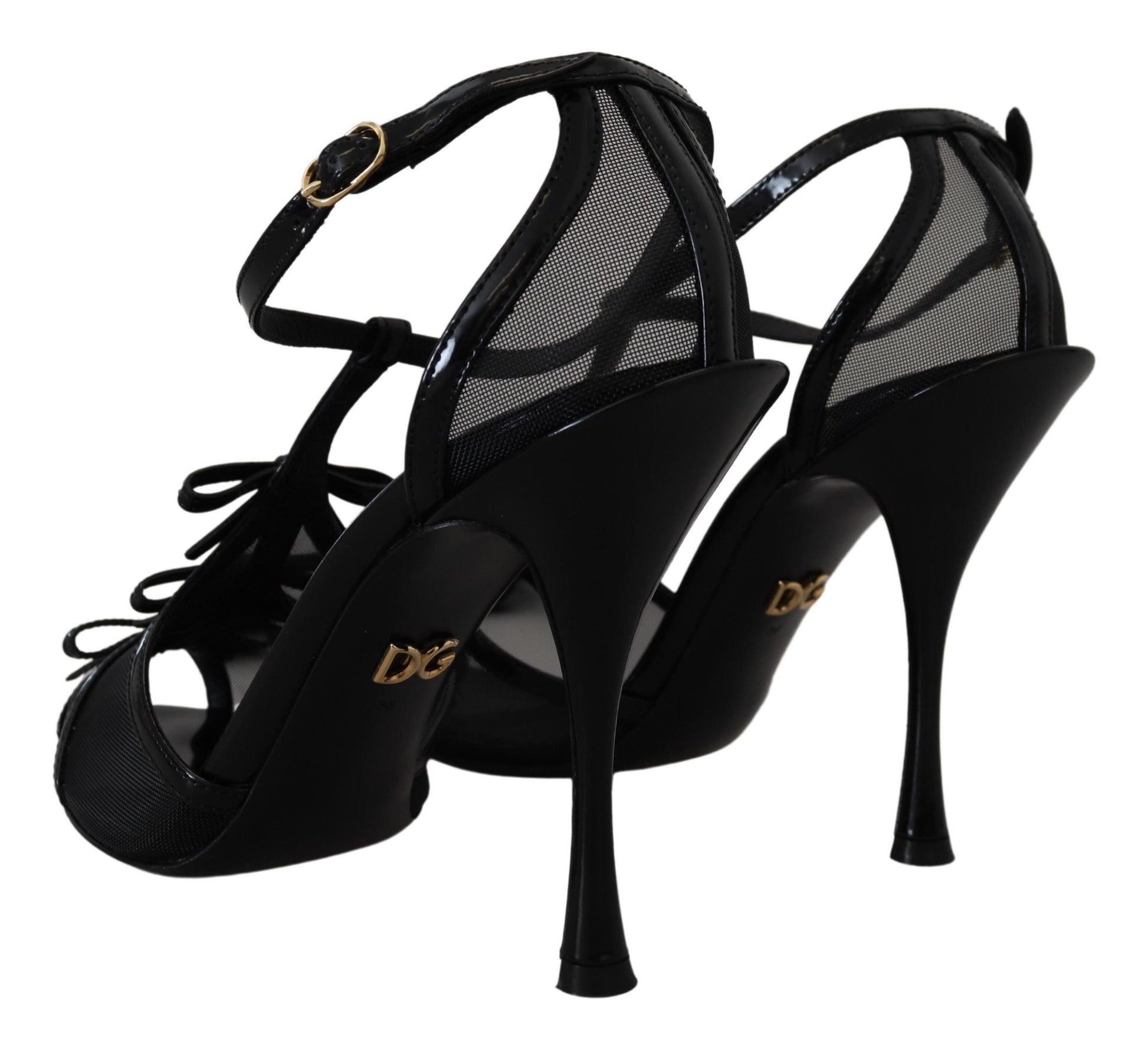 Pair of black high heel shoes with gold accents and a bow on top