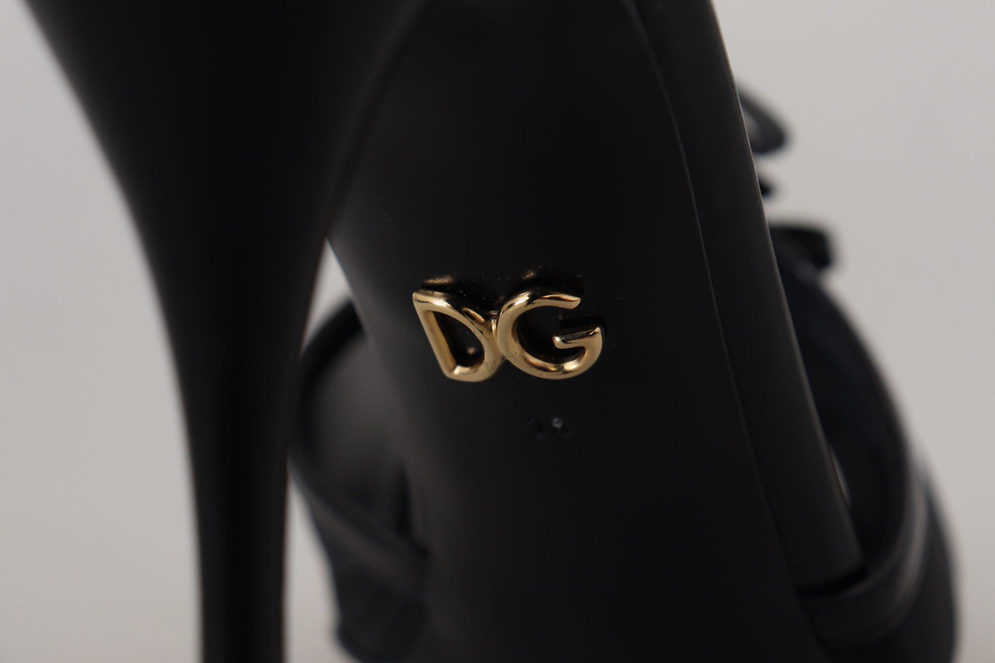 Black high heel shoe with gold logo on side