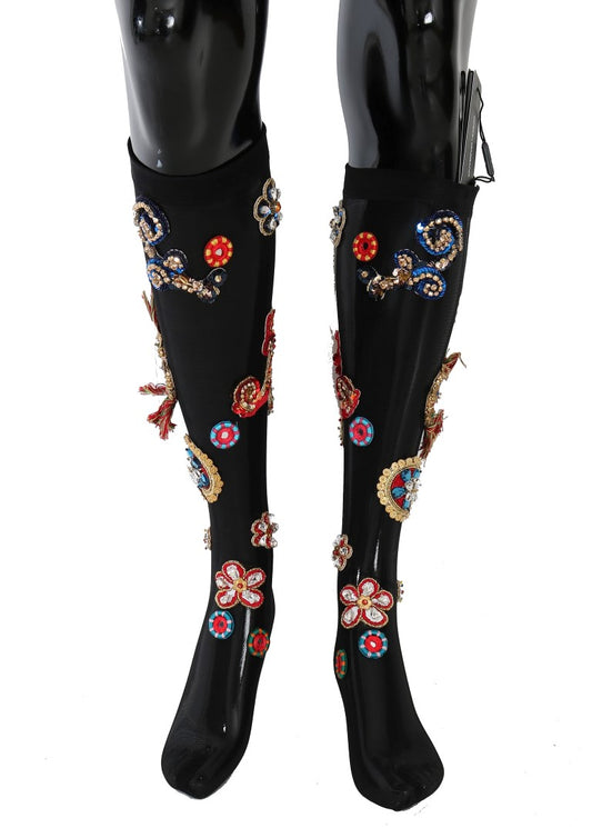 Pair of black knee high boots with floral embroidery on sides