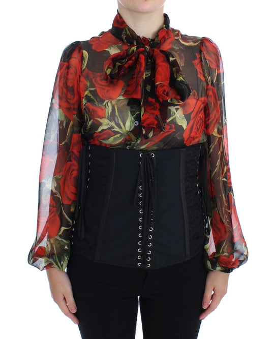 Woman wearing black pants and a red floral blouse with puffy sleeves