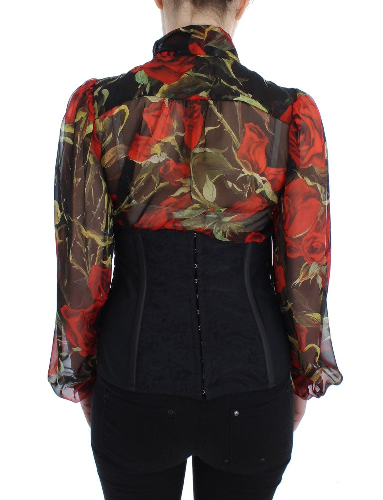 Woman wearing a red floral top with black lace sleeves and a black corset