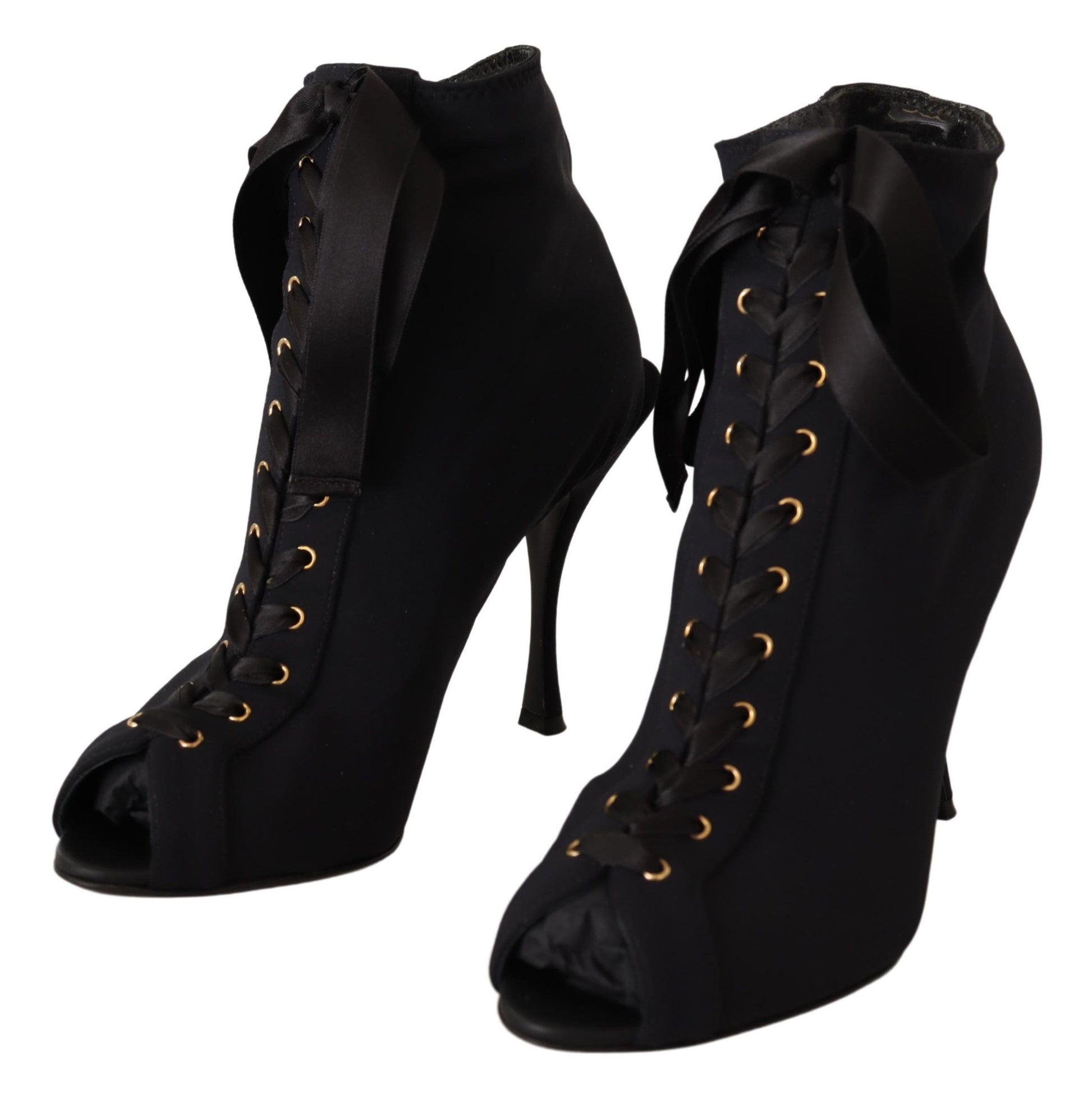 Pair of black high heel boots with gold buckles and laces