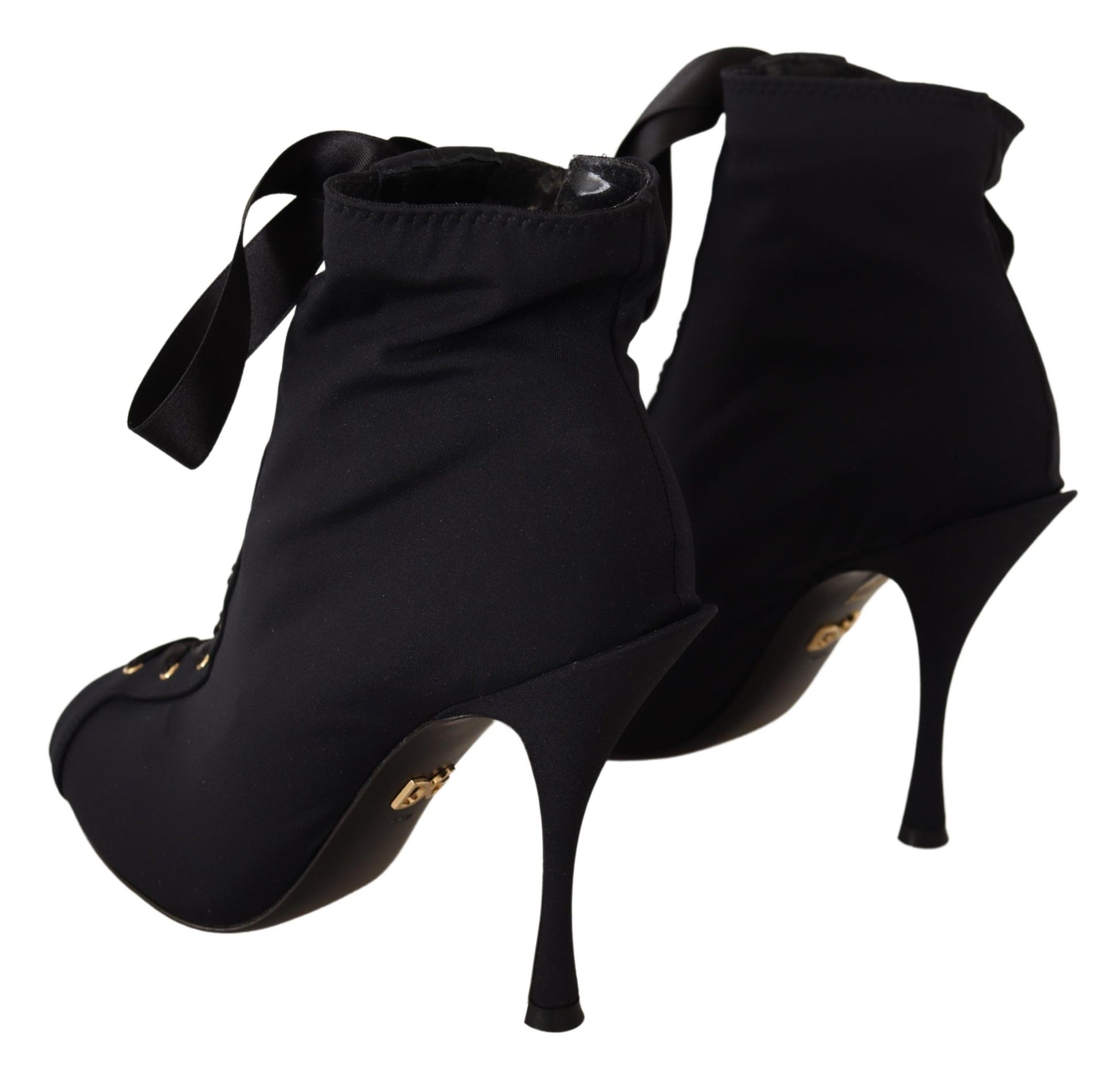 Pair of black high heel shoes with ankle straps and a bow on top