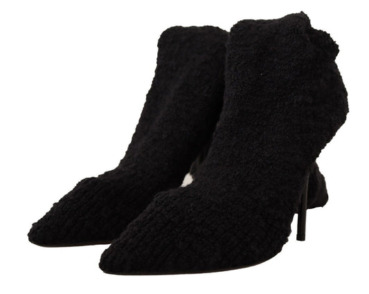 Pair of black suede boots with fur trim and heels