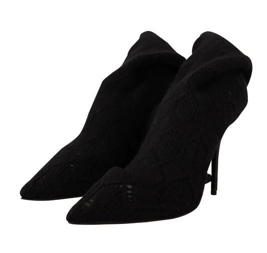 Pair of black knee high boots with fur trim and heels