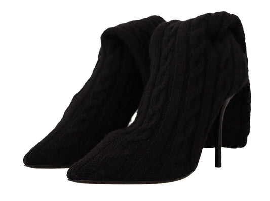 Pair of black boots with fur trim and a heel