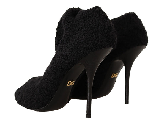 Pair of black high heel shoes with fur trim and gold lettering on soles
